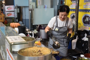 국밥（クッパ）を店先で作る女性